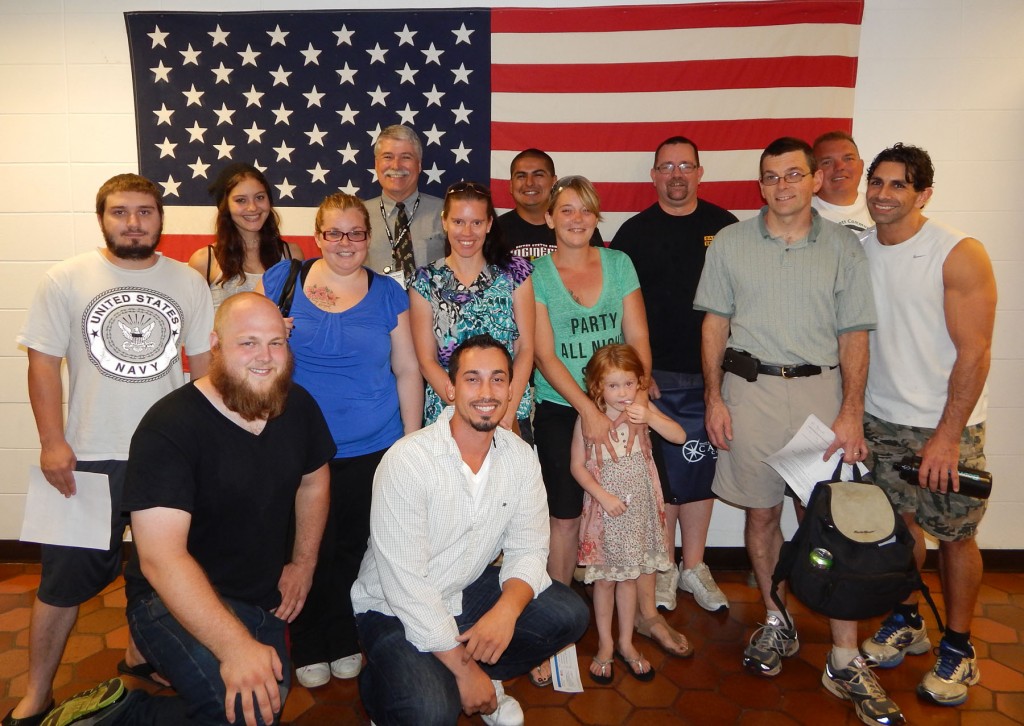 Group of veteran students with Veterans Director, Bob Mayer, in front of the American flag