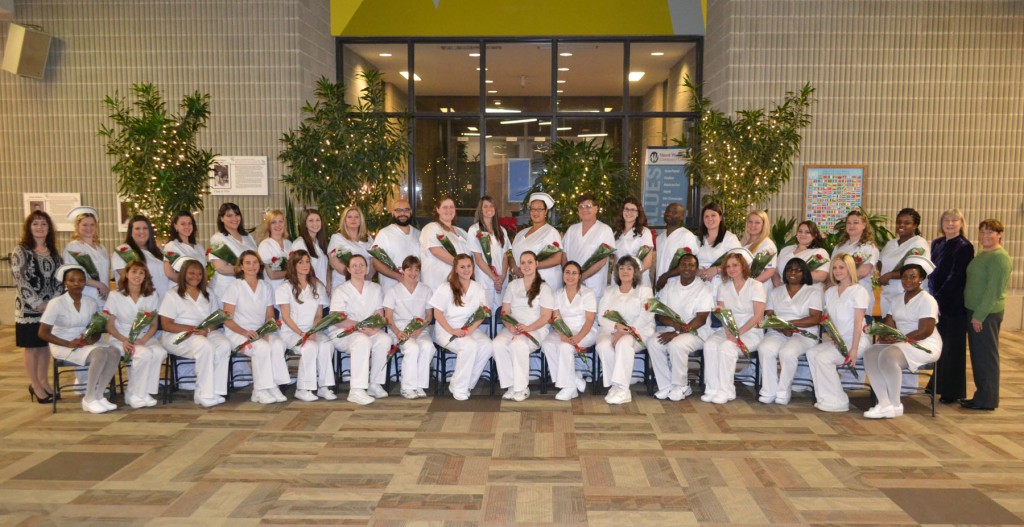 Group of nursing graduates in their nursing attire with flowers in the Commons