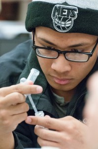 Closeup of student with glasses looking at an eyedropper