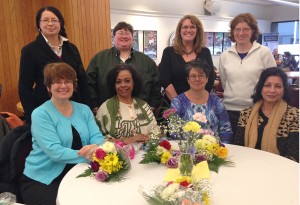 Group of women mentors sitting at a table with flowers on it