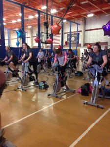 Group of participants riding their spin bikes in the open gym area