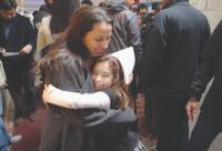 Graduate receiving a hug from a child