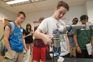 Student using the robotic arm as others look on