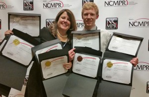 Lea Ann Scales, Vice President of External Affairs, Communications and K-12 Partnerships and Brett Moulton, Web and New Media Specialist, with the college's nine NCMPR Medallion Awards.