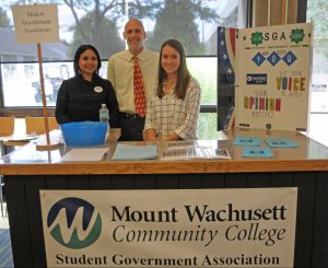 President Vander Hooven with two SGA members behind the SGA booth