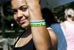 Girl holding up her write with Goals for Nets bracelets on it